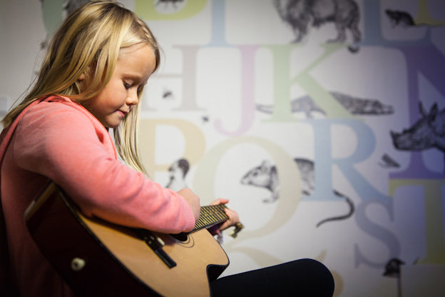 en flicka spelar gitarr