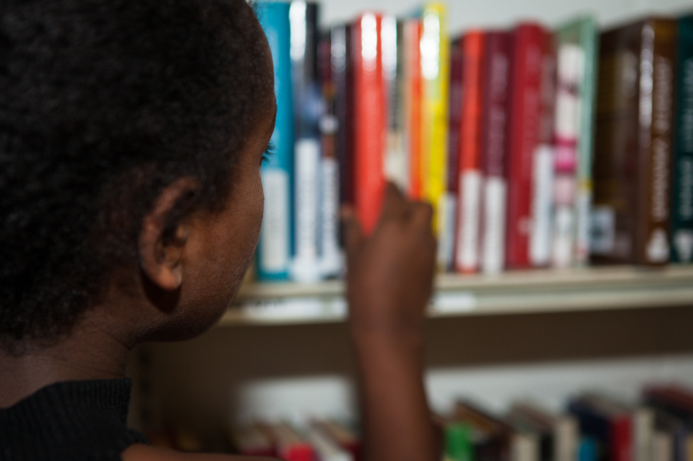 ett barn tar en bok från hyllan