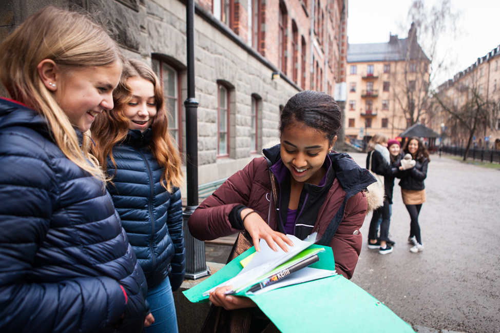 Tjejer tittar i en pärm