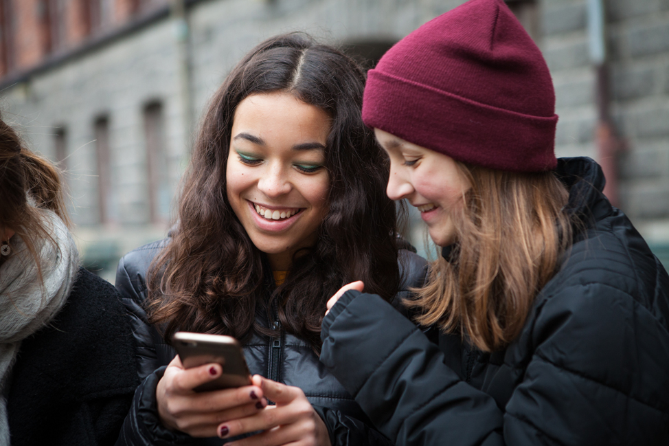 Två tjejer tittar i en mobil