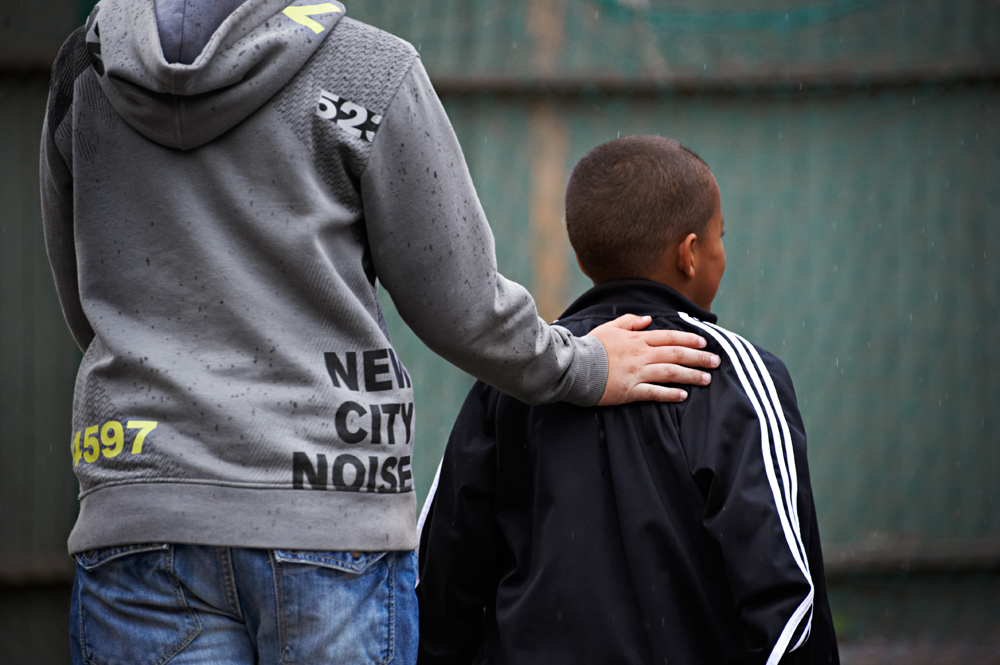 Storebror som hållar handen på lillebrors axel